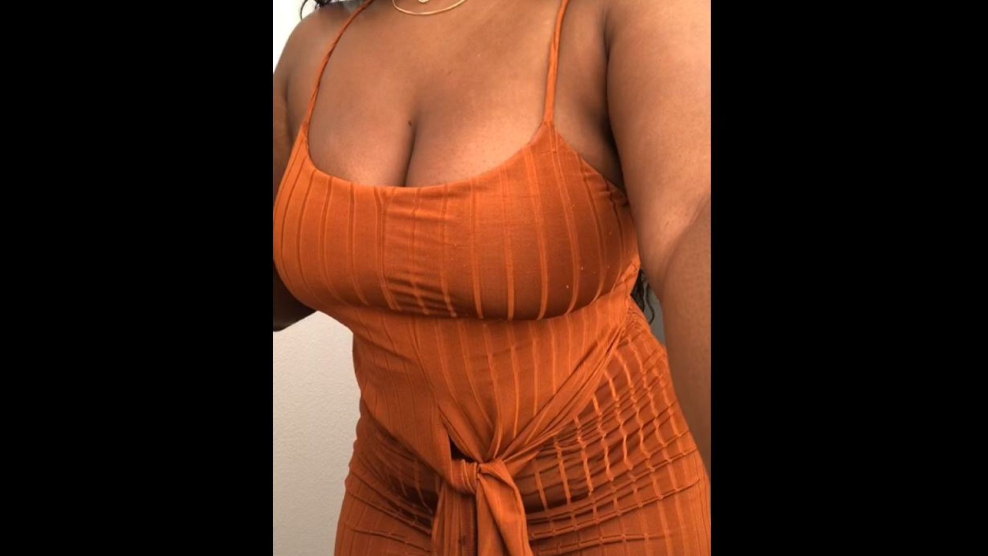 elle montre ses gros seins dans une robe orange à ses fans